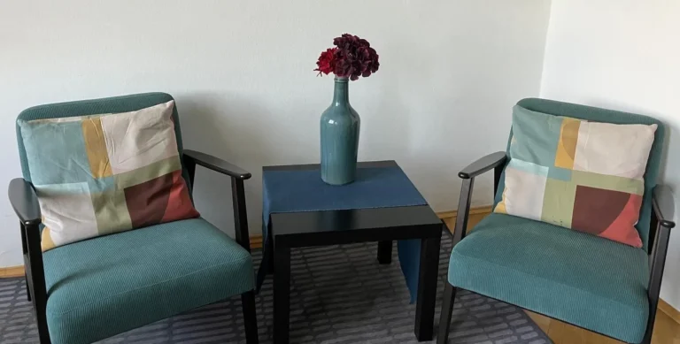 Interiér moderní psychoterapeutické ordinace v Praze – dvě pohodlná křesla pro párovou a individuální terapii.