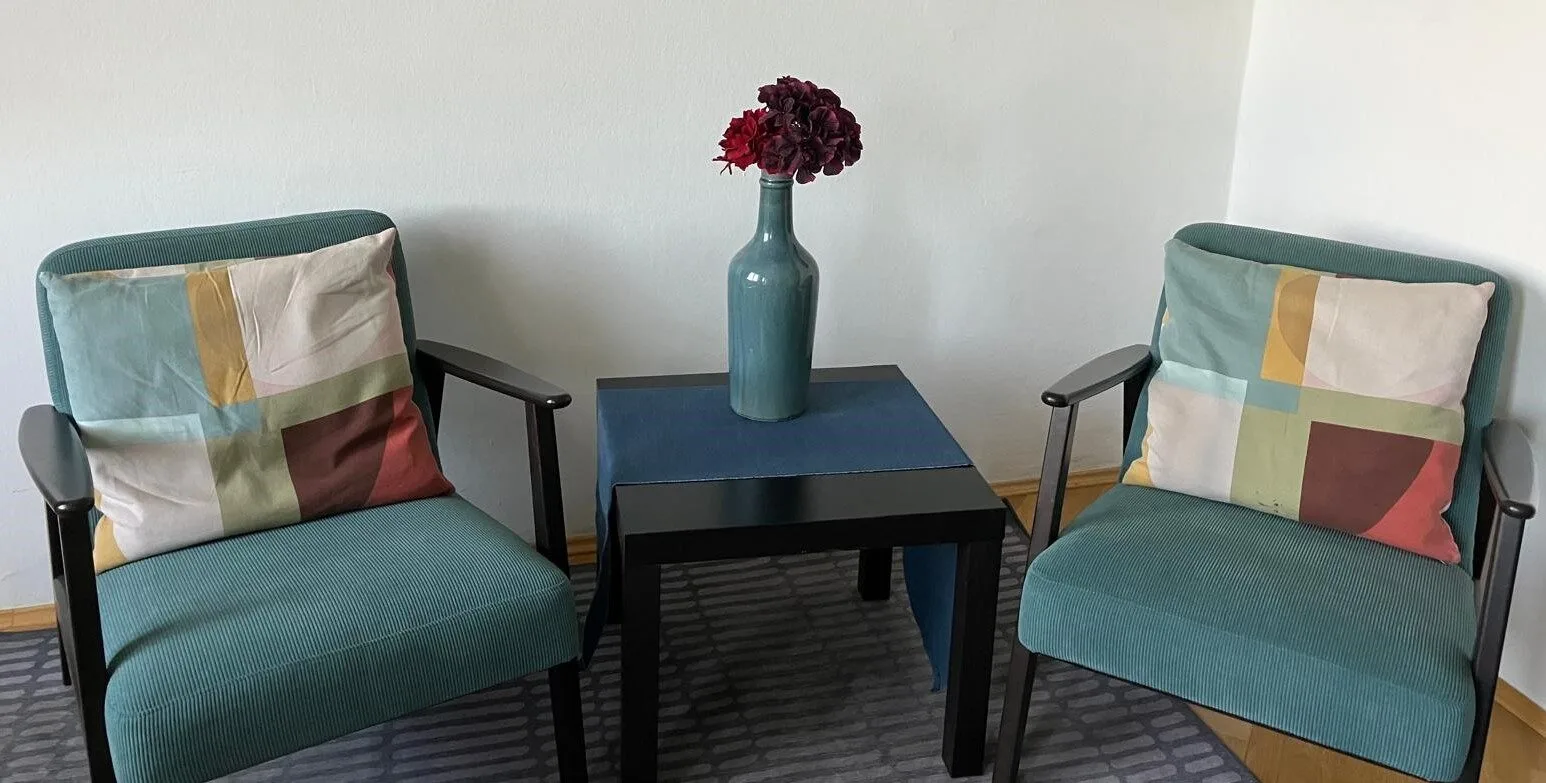 Interiér moderní psychoterapeutické ordinace v Praze – dvě pohodlná křesla pro párovou a individuální terapii.