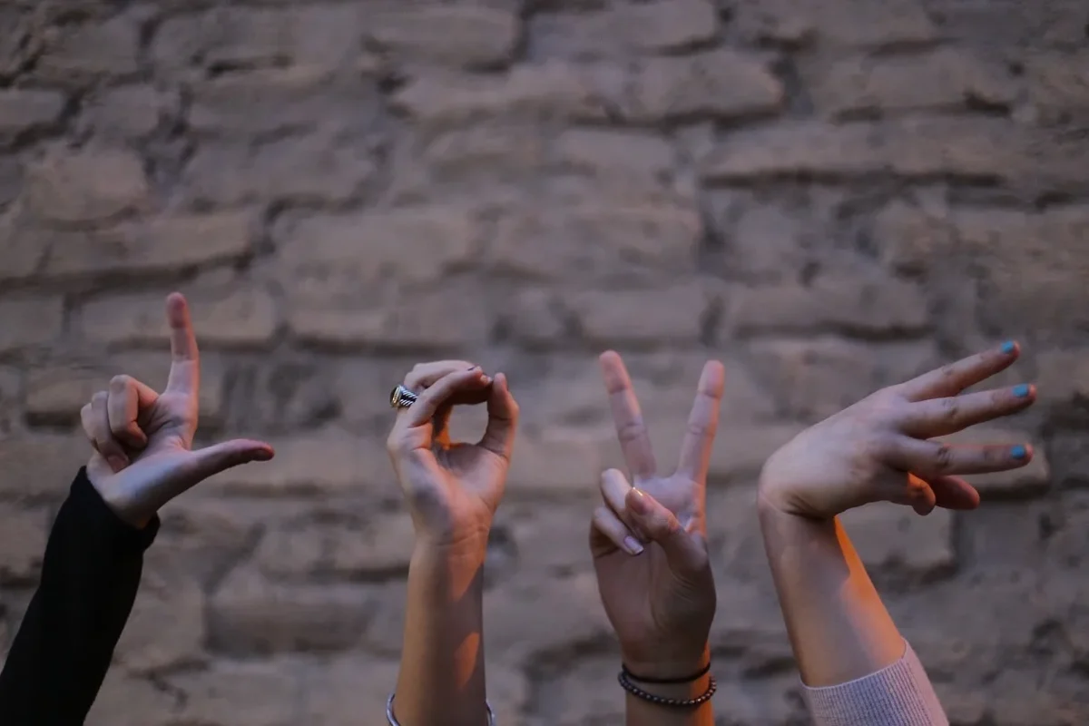 Gesta rukou symbolizující slovo „LOVE“ a otevřenou komunikaci v rámci terapeutické skupiny.